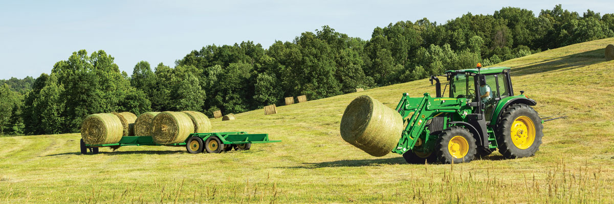 small tractor carrying hay