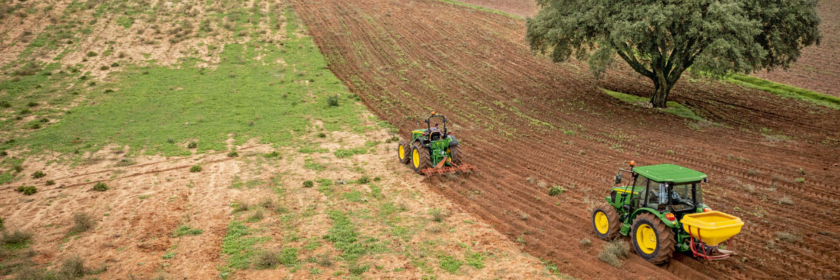 john deere small tractor on slope farm land