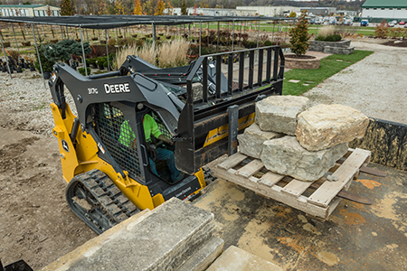 John Deere 317G equipped with pallet forks